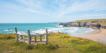 An,Empty,Park,Bench,Overlooking,Seascape,Landscape,Of,Porthcothan,Beach